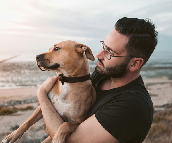 A man holding a brown dog
